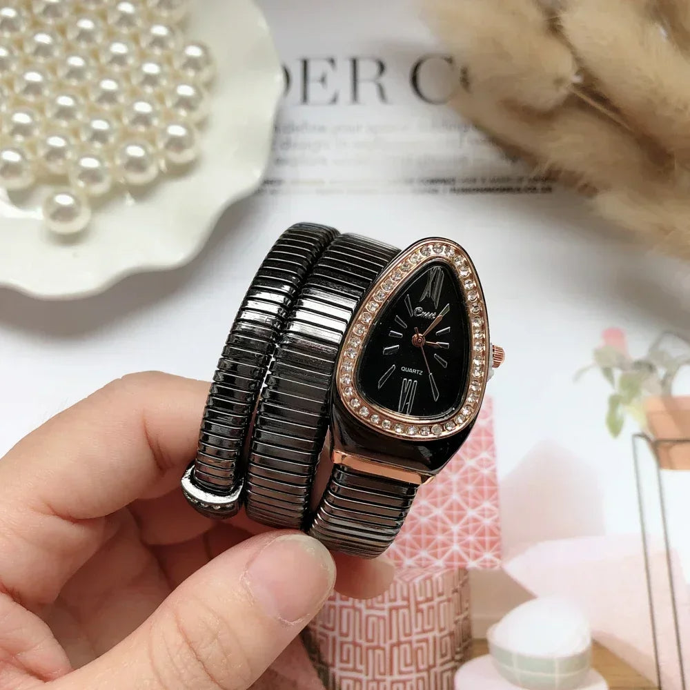 Black and rose gold watch held in a hand with decorative items in the background