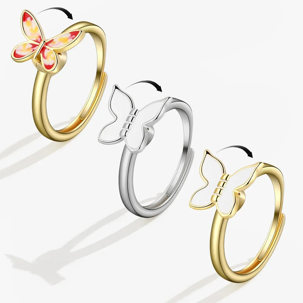 Three butterfly-shaped rings in gold, silver, and gold on a white background