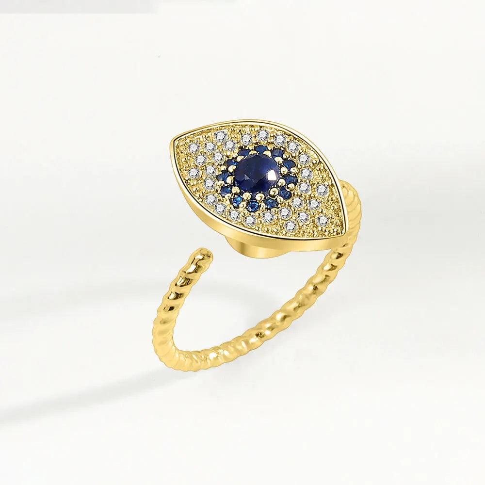 Gold ring with a blue gemstone like eye on a white background