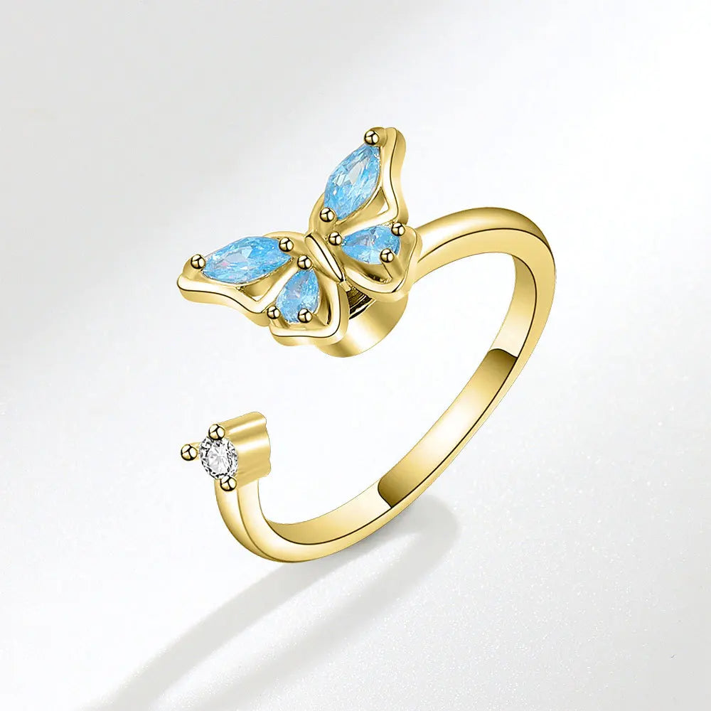 Gold ring with blue gemstones on a white background
