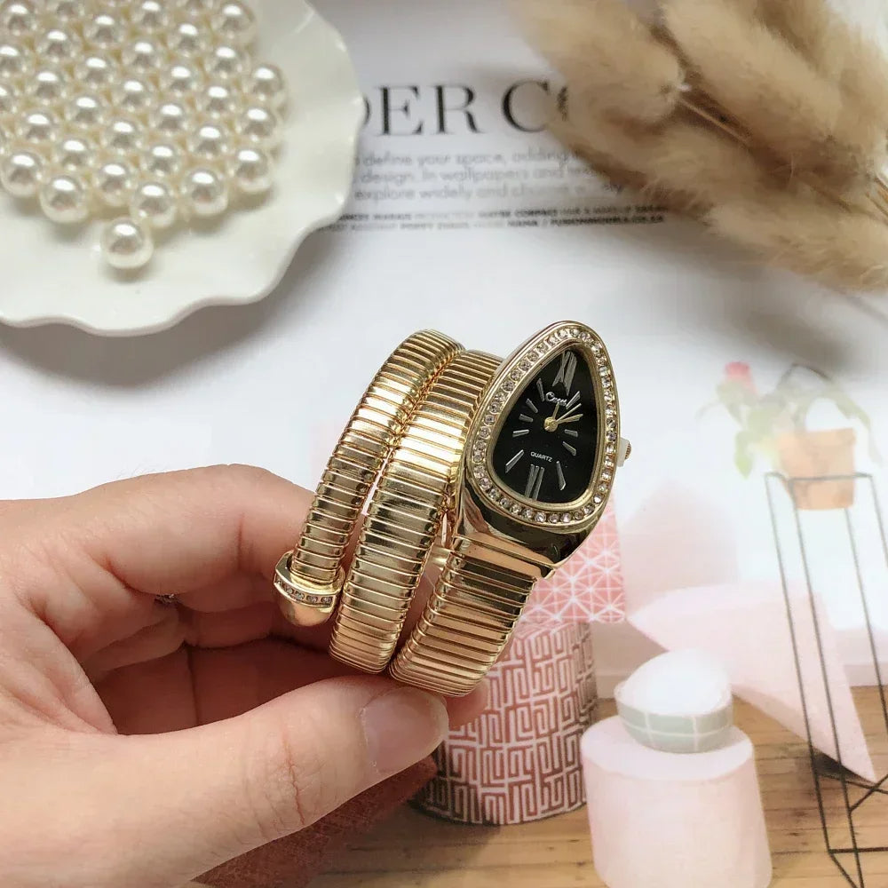 Gold watch with multiple bands held by a hand on a magazine background