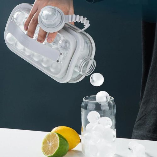Hand using a clear ice cube tray to fill a glass with ice cubes, surrounded by lemons on a dark background.