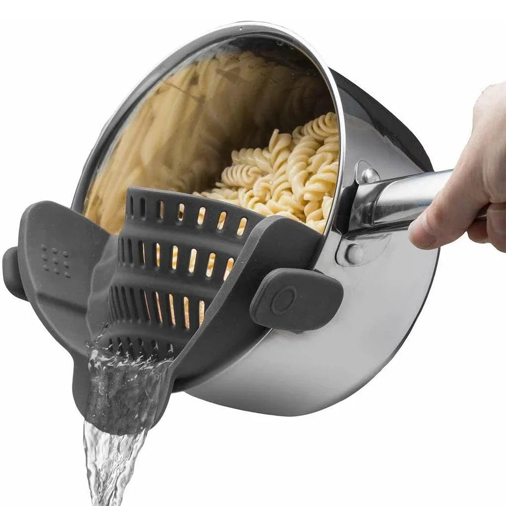 Pasta being drained from a pot with a pasta strainer.
