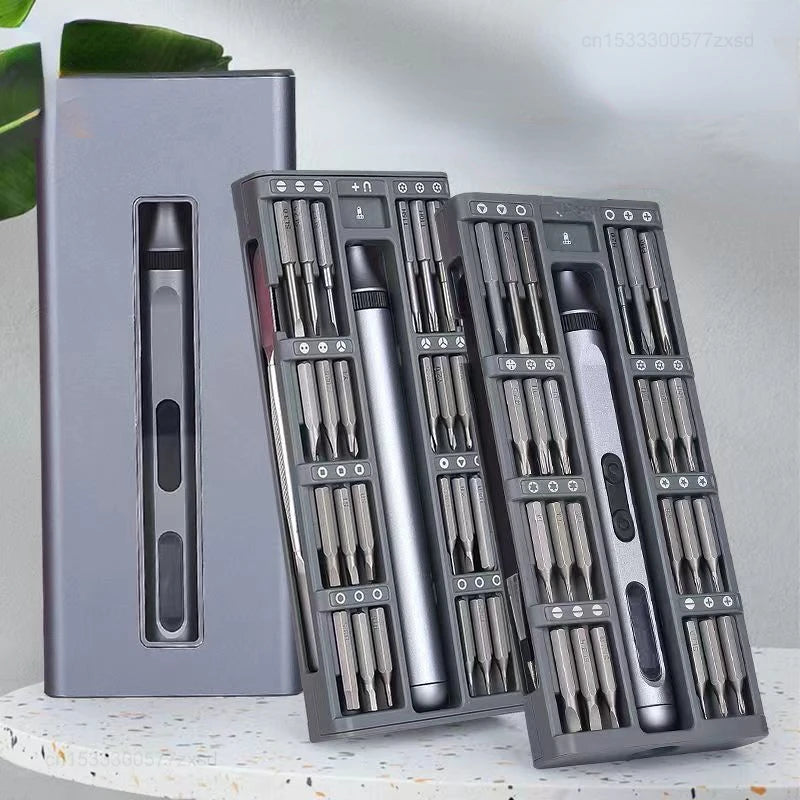 Set of screwdrivers in a gray case on a light surface with a green leaf in the background