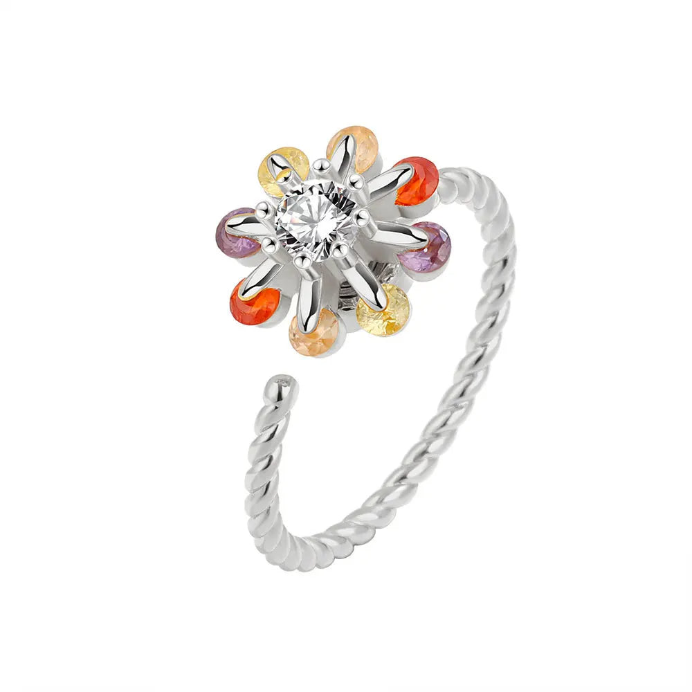 Silver ring with a central gemstone and colorful gemstones on a white background
