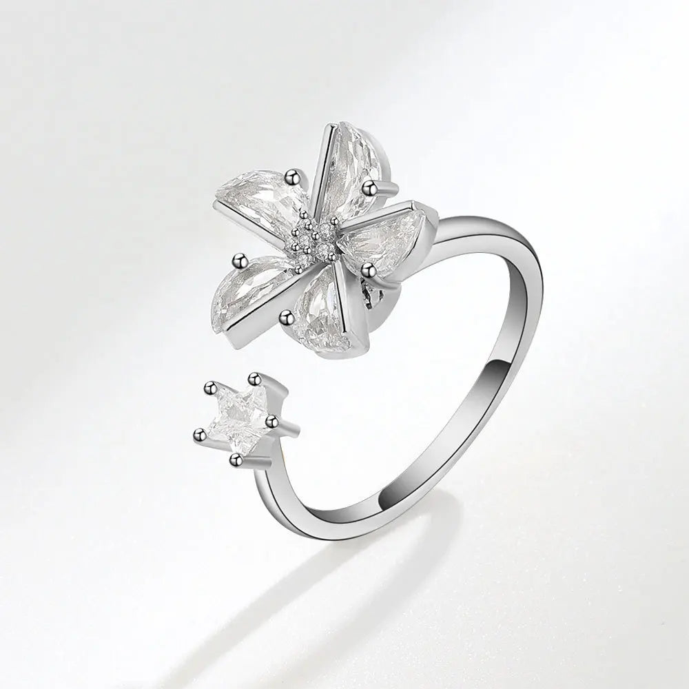 Silver ring with floral design on a light gray background