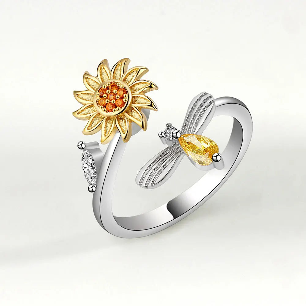Silver ring with sunflower and dragonfly design on a white background