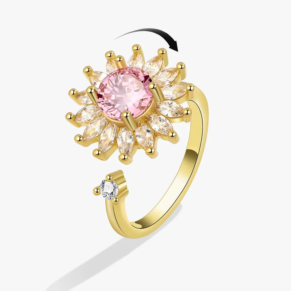 Gold ear cuff with pink and clear gemstones on a white background