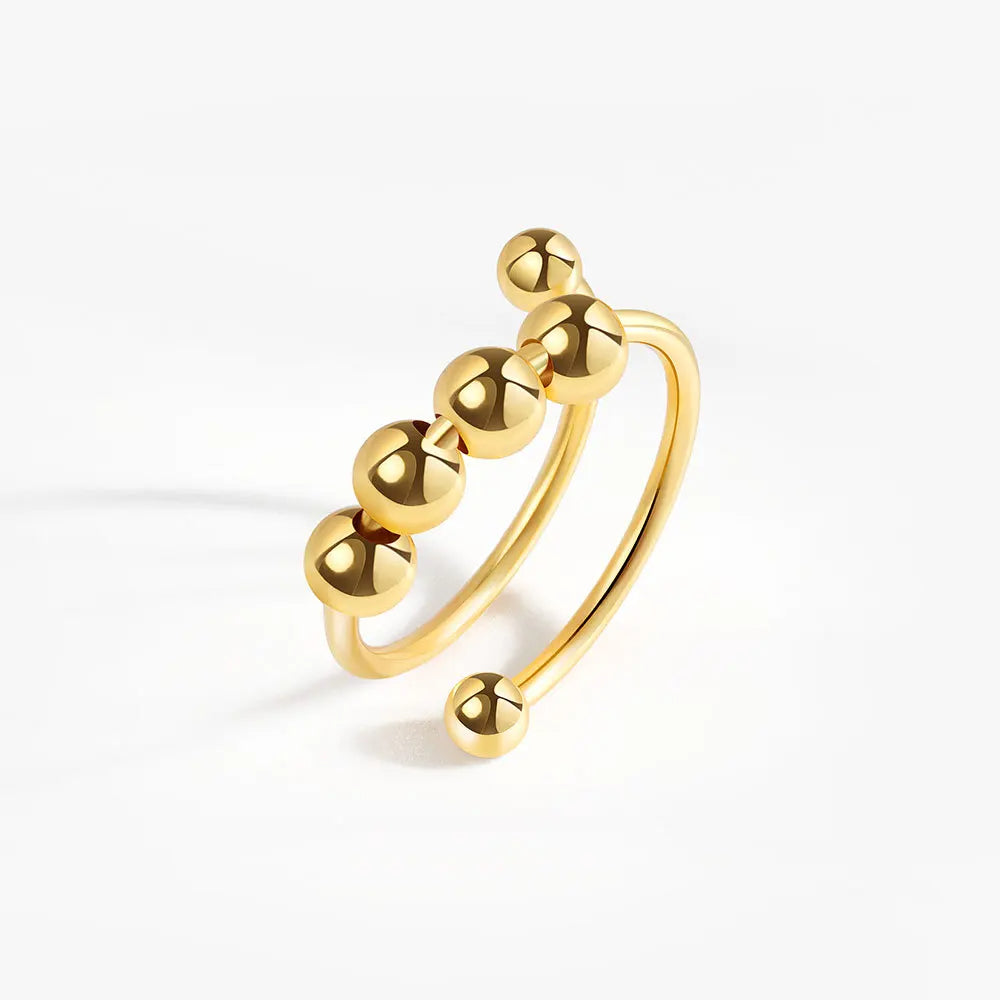 Gold ring with five spherical beads on a white background