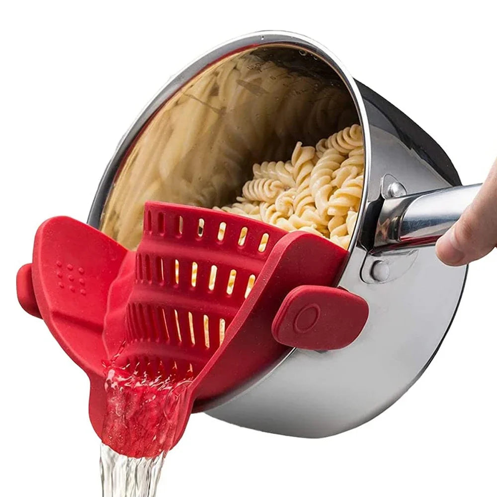 Red silicone strainer being used to drain pasta from a pot.