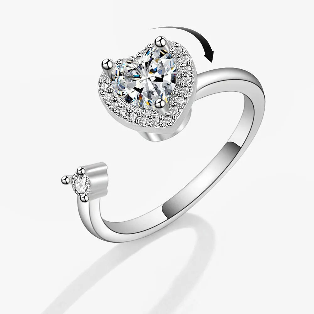 Silver heart-shaped ring with a large central gemstone on a white background
