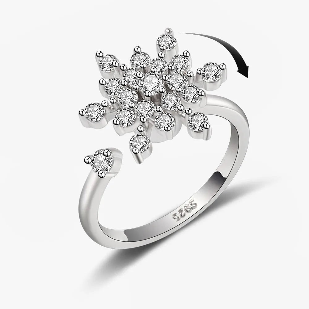 Silver ring with diamond flower design on a white background