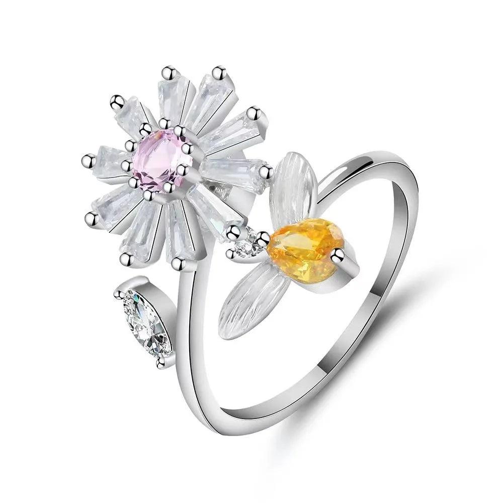 Silver ring with floral design and gemstones on a white background