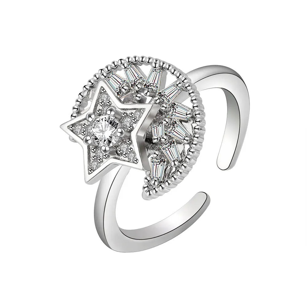 Silver ring with star design and clear gemstones on a white background