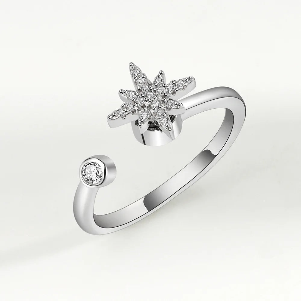 Silver ring with star-shaped gemstone on a light gray background
