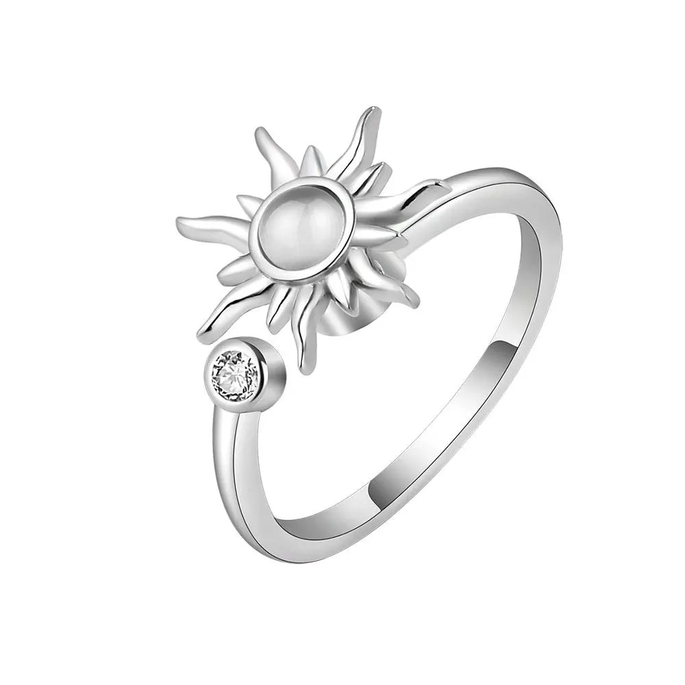 Silver sun-shaped ring with a small gemstone on a white background